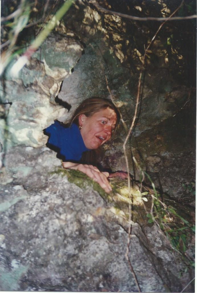 een-vrouw-klimt-een-grot-in