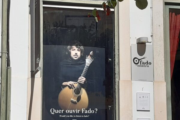 Poster van een fado gitarist achter een raam in Lissabon