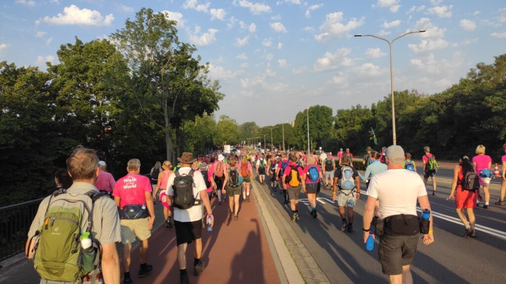 Grote groep wandelaars in het ochtendgloren, tijdens de Vierdaagse van Nijmegen.