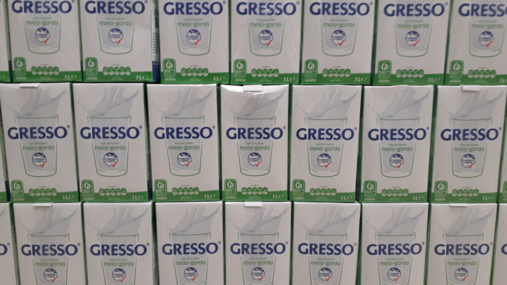Symmetrische foto van een schap in een supermarkt met pakken halfvolle melk in Portugal.