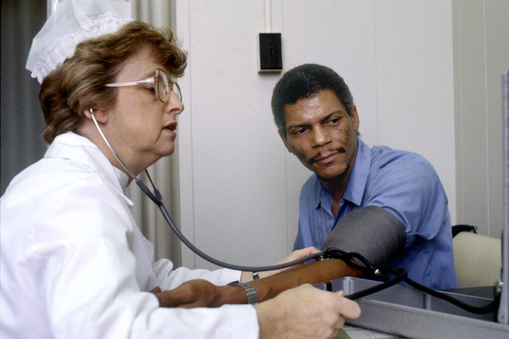 Verpleegkundige neemt de bloeddruk op van een man.