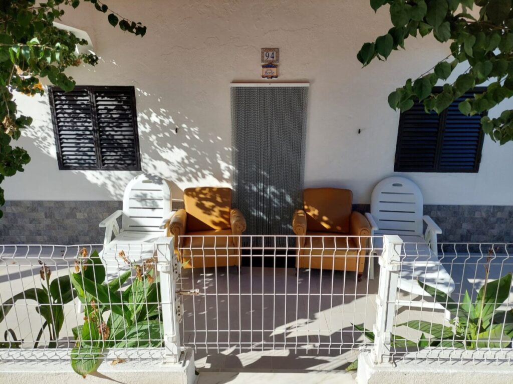 Klein huisje op Armona in Portugal met keurig symmetrisch 4 stoelen voor/naast de deur.