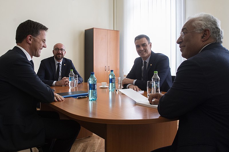 Vier regeringsleiders aan een kleine vergadertafel. 