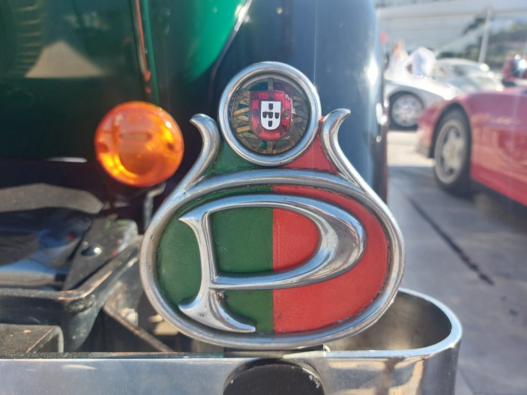 Oude auto, oldtimer, in Albufeira, Portugal, met een bumperschild in de kleuren van de Portugese vlag.