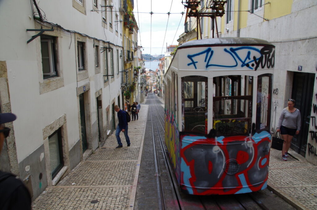 Een andere funicular in Lissabon met mensen op de trappen ernaast.