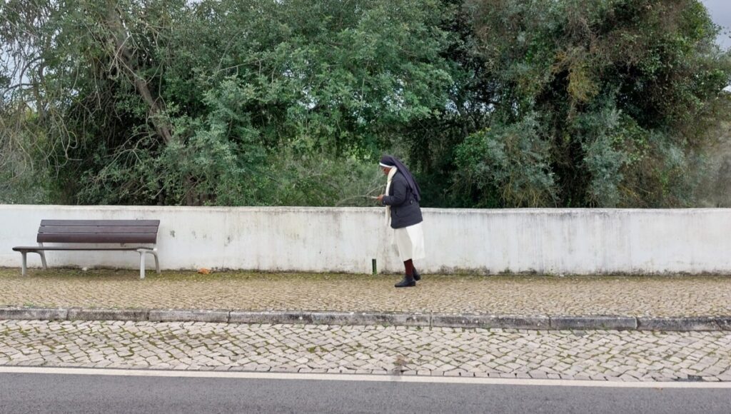 Een non op een kasseienweg (calçada Portuguesa)