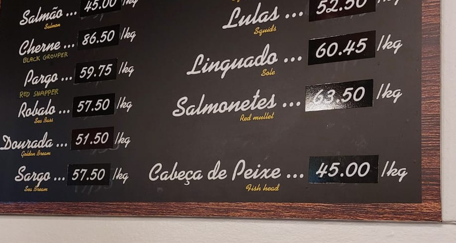 Portugese menukaart aan de muur met dagprijzen voor vis.