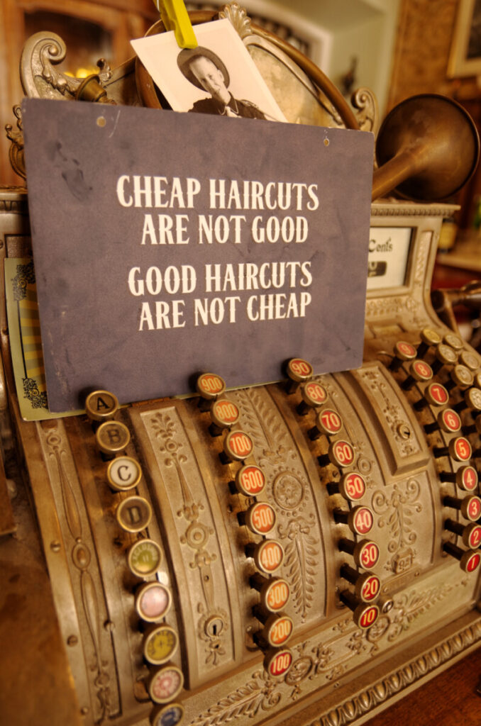 Een ouderwetse kassa met het opschrift dat goede kappers niet goedkoop zijn.