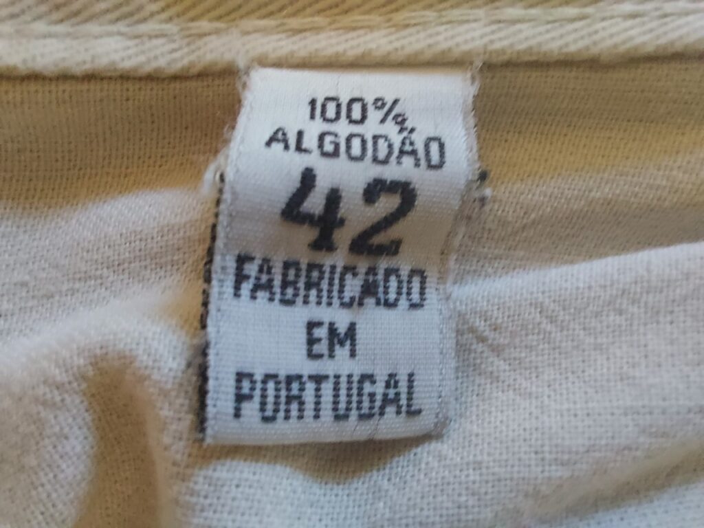 Neketiket uit een kledingstuk met de tekst '100% Algodão 42 fabricado em Portugal.