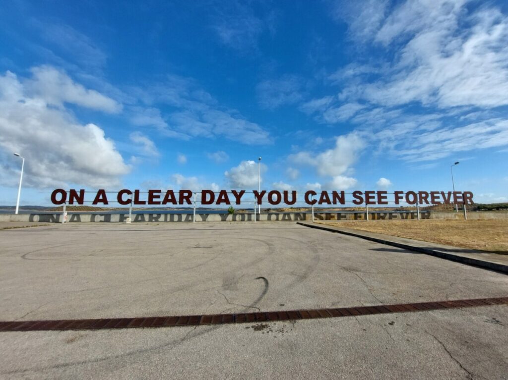 De spreuk 'On a clear day you can see forever' in enorme letters bij het stuwmeer Alqueva in Portugal