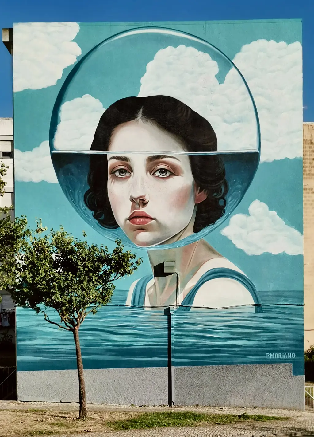 Afbeelding op een muur van een vrouw met haar hoofd in een glazen bol.