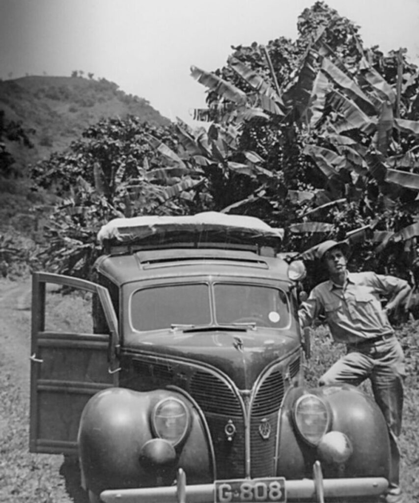 Klassieke auto in Afrika met reiziger ernaast