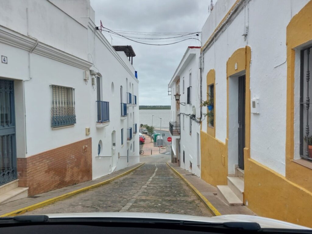 Uitzicht door een smal straatje op de rivier de Guadiana in Ayamonte, Spanje.