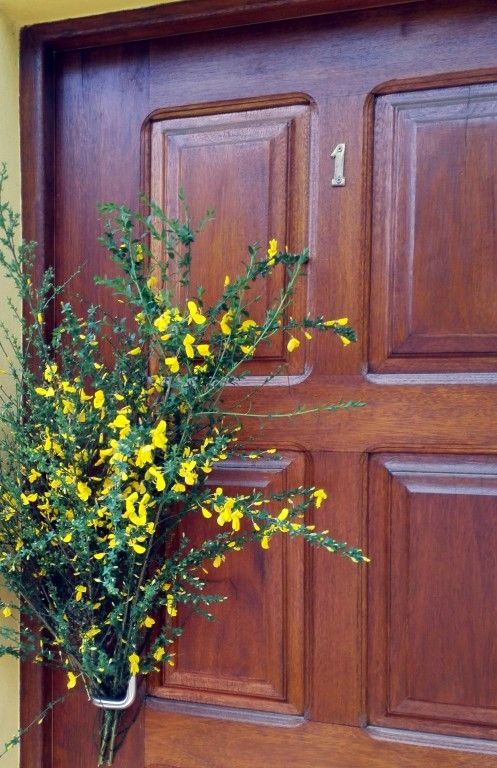 een bos brem aan de voordeur geklemd